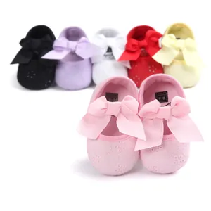 Detail view of pink infant princess shoes with delicate floral embroidery and ribbon bows