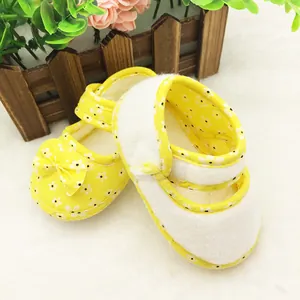Detailed view of yellow floral baby shoes featuring soft soles and a cute bow design