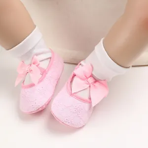 Gros plan détaillé de chaussures de princesse roses pour bébé avec un grand nœud
