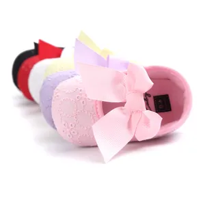 Detailed view of colorful embroidered baby princess shoes with large bows