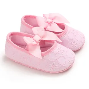 Gros plan de chaussures de princesse roses pour bébé avec broderie florale et nœud