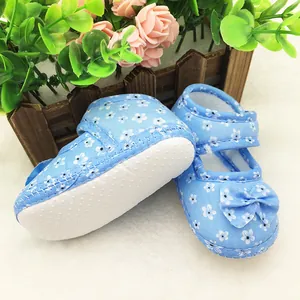 Macro view of blue floral baby shoes featuring non-slip soft soles and cute decorative bow