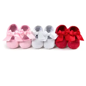 Detailed view of baby girl princess shoes in pink, white, and red with large bows