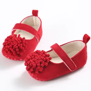 Primer plano de zapatos rojos para bebé con flor 3D grande y detalle de suela blanda.