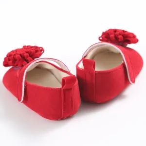 Detalle en primer plano de zapatos de princesa rojos con suela blanda y flores