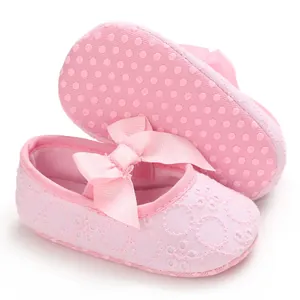 Détail de chaussures de princesse en dentelle rose pour bébé avec nœud et semelle souple antidérapante
