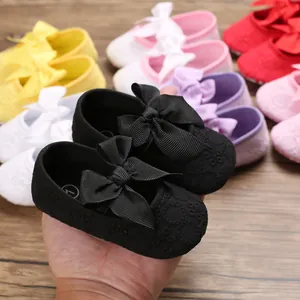 Gros plan de chaussures de princesse pour bébé à semelle souple avec dentelle et nœud