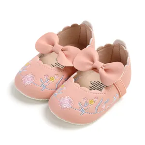 Detailed view of pink baby princess shoes with floral embroidery and bow accents