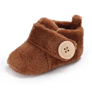 Close-up of soft brown plush baby walking shoe with a large decorative wooden button