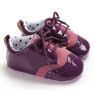 Detail of purple patent leather baby shoes with brogue perforations and star print lining
