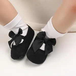 Vue détaillée des chaussures de princesse en dentelle noire avec de grands nœuds