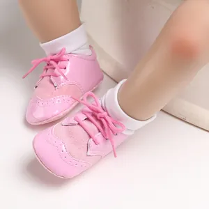 Close-up of pink baby pre-walker shoes with soft soles and lace-up design