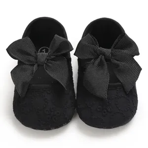 Vue détaillée de chaussures de princesse bébé noires avec nœuds en ruban et broderies