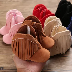 Close-up of soft suede baby boots featuring stylish fringe tassels and side zipper