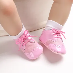 Detailed view of pink soft-sole baby pre-walker shoes with elegant brogue pattern design