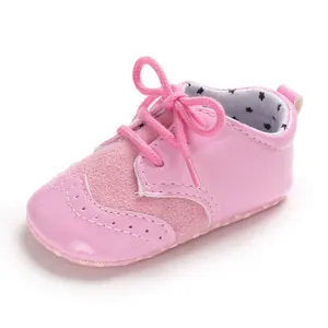 Detailed view of pink infant pre-walker leather shoes with brogue patterns and star lining