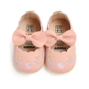 Top down view of pink baby princess shoes with floral embroidery and large pink bows