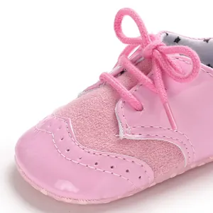 Close-up of pink baby walker shoe featuring glossy finish and decorative bow tie detail