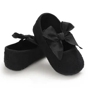 Détail de chaussures de princesse bébé en dentelle noire avec nœud en ruban