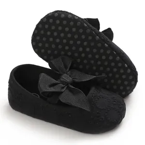 Détail de chaussures de marche pour bébé à semelle souple noire avec nœud