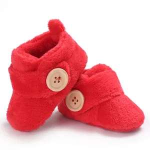 Close-up of soft red plush baby walking shoes featuring a decorative wooden button