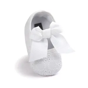 Detailed view of white embroidered baby princess shoe featuring a large elegant ribbon bow