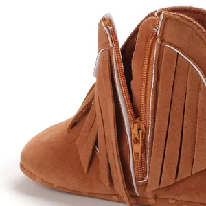 Close-up of brown suede baby fringe boots with side zipper detail