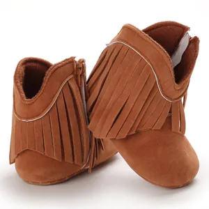 Detailed close-up of stylish brown suede baby boots with decorative tassel fringe