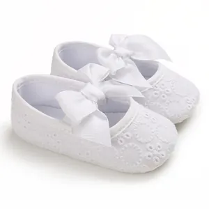 Vue détaillée de chaussures de princesse pour bébé en dentelle blanche avec nœuds