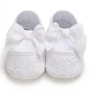 Gros plan détaillé de chaussures de marche pour bébé en dentelle blanche avec de grands nœuds