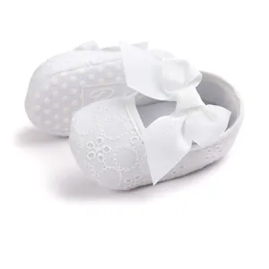 White embroidered princess baby walker shoes with a large decorative ribbed bow detail