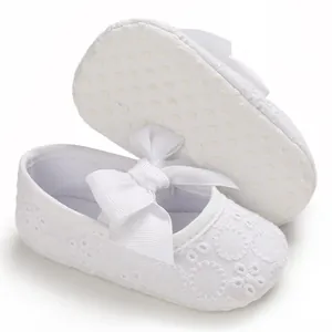 Détail de chaussures de princesse bébé blanches avec dentelle et semelle souple antidérapante