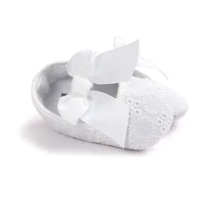 Detailed view of white embroidered baby princess walking shoe with large satin bow