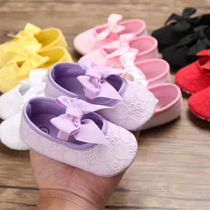 Gros plan de chaussures de princesse pour bébé avec nœuds et broderie fine