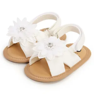 Vue détaillée de sandales blanches pour bébé avec fleurs en perles et semelles souples
