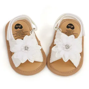Vue détaillée de sandales blanches pour bébé avec de grandes fleurs et perles
