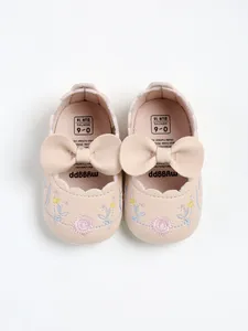 Top view of pink baby princess shoes with leather bows and delicate floral embroidery.