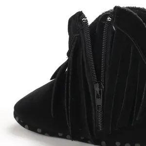 Detailed close-up view of black velvet baby boot featuring side zipper and fringe tassels