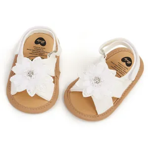 Vue détaillée de sandales blanches pour bébé avec fleurs en dentelle et perles sur semelles souples