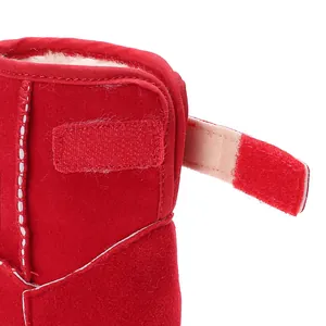 Λεπτομερής λήψη κόκκινης παιδικής μπότας χιονιού με βέλκρο και ζεστή βελούδινη επένδυση.