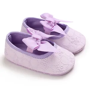 Détail de chaussures bébé princesse lilas avec broderie florale et nœud ruban.