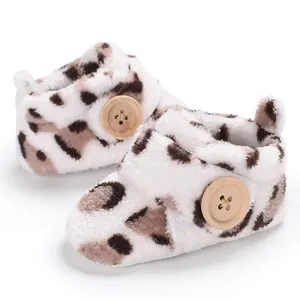Macro view of plush leopard print infant walking shoes with wooden button detail