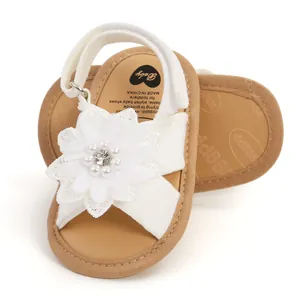 Détail de sandales blanches pour bébé avec fleur décorative et semelle souple pour enfants