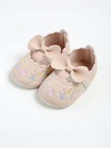 Pink embroidered baby princess shoes with a large leather bow and scalloped edge detail