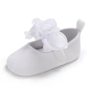 Nahaufnahme eines eleganten weißen Baby-Prinzessin-Schuhs mit feiner Stoffblumendekoration.