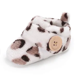 Close-up of leopard print baby fleece shoes with a decorative wooden button detail