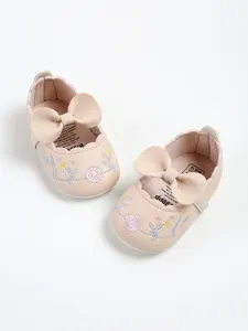 Detailed view of pink embroidered baby princess shoes featuring delicate floral patterns and bow