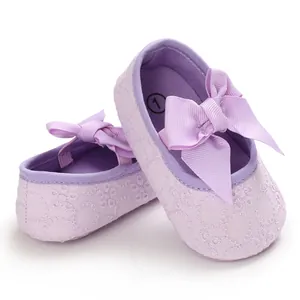 Gros plan de chaussures de princesse pour bébé violettes avec broderie florale.