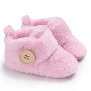 Close-up of pink fuzzy baby pre-walker boots with a large decorative wooden button.