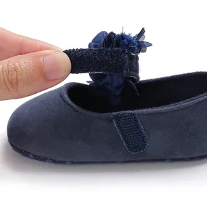 Detailansicht von dunkelblauem Baby-Prinzessinnenschuh mit Blume und Klettverschluss